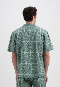 Korte mouwen shirt van textuurstof, met een groen en lichtgroen abstract zwirlpatroon, een notch-kraag en een ontspannen pasvorm.