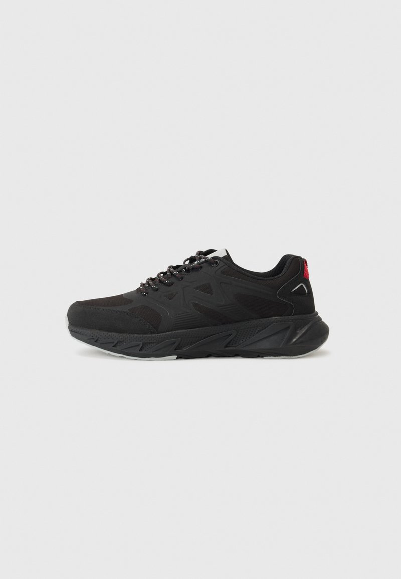 Black athletic shoe features a mesh upper with synthetic overlays, a cushioned sole, and contrasting red accents on the heel.