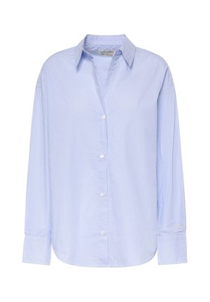 Chemise bleu clair à manches longues boutonnée, avec fines rayures blanches verticales, col pointu et larges poignets sur fond blanc uni.