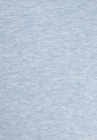Světle modrá látka s texturovaným, mírně žíhaným vzorem. Materiál se zdá být jemný a pružný, vhodný pro každodenní nošení.