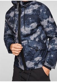 Marinblå och grå mönstrad jacka med huva, som har dragkedja, framficka med knapp och justerbar dragsko i nederkant.