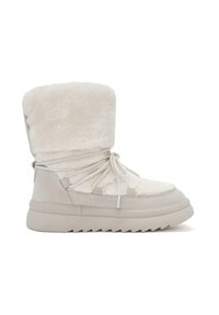 Botas de tobillo forradas de pelaje sintético en suave blanco, con un diseño de encaje en la parte delantera, parte superior texturizada y suela de goma gruesa con un patrón en zigzag.