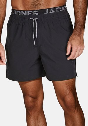 Pantaloni da nuoto neri con elastico in vita e cordino grigio. Tessuto morbido, tasche laterali, lunghezza sopra il ginocchio, design minimale.