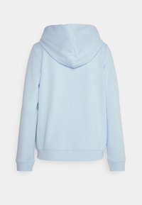 Ljusblå luvtröja, mjukt tyg, långa ärmar, ribbade muddar och nederkant. Minimalistisk design utan synliga logotyper eller mönster.