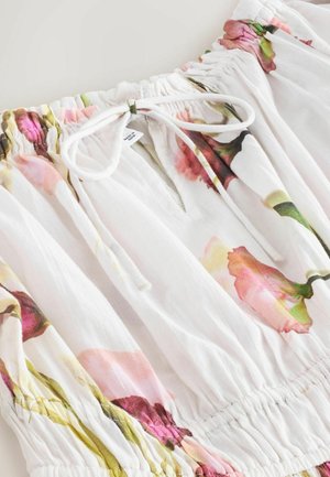 Witte blouse met bloemenprint in roze en groen. Heeft een gerimpelde halslijn, strikdetail en zachte, lichte stof met een vloeiend ontwerp.