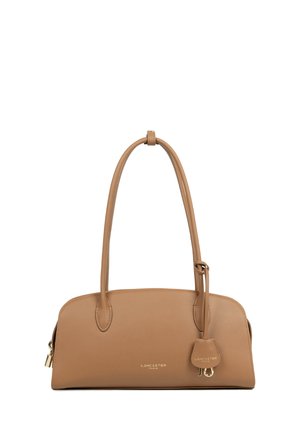 Sac à main en cuir fauve au design épuré, avec deux poignées et une étiquette suspendue décorative ornée de ferrures dorées et de la marque.