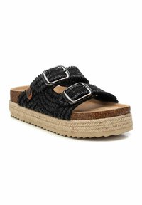 Sandalias deslizantes negras de tejido trenzado con doble hebilla plateada, plantillas de corcho y suela de estilo yute. Tejido texturizado con un patrón trenzado.