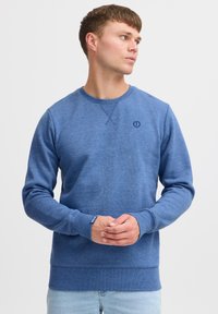 Blue sweatshirt with a textured finish and a round neck. Features ribbed cuffs and hem, plus a small logo on the chest.