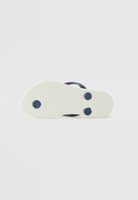 Suela de chancla de color azul marino con base de goma blanca texturizada, que presenta dos hendiduras en forma de círculo y un acabado suave.