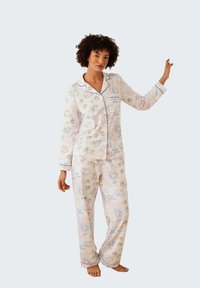 Pajamaset i mjukt, lätt tyg med ett pastellmönster av matvaror. Utsmyckad med blå kantning, inkluderar långärmade tröjor och lösa byxor.