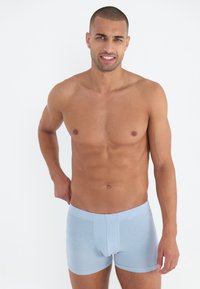 Boxeri scurți de culoare albastru deschis, confecționați dintr-un material moale, cu o potrivire strânsă, un tiv elastic și fără modele sau elemente decorative vizibile.