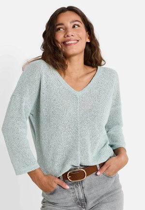 Pull en maille bleu clair avec un col en V et des manches trois quarts. Coupe ample, avec une texture complexe et un style décontracté.