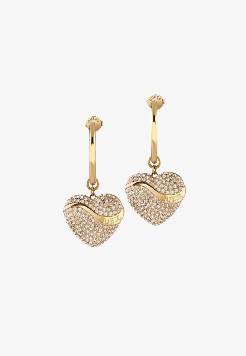 Boucles d'oreilles en forme de cœur doré avec un pavé de cristaux transparents, un accent ondulé et un logo de marque gravé. Design en créole avec une fermeture sécurisée.