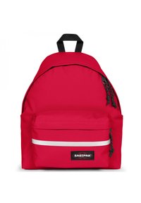 Mochila de tela roja con forma redondeada, bolsillo con cremallera en el frente y una franja reflectante blanca. Presenta herrajes y logotipos en negro.