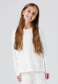 Ensemble de pyjama blanc à manches longues, avec un motif floral en rose et vert. Confectionné en tissu doux avec une coupe décontractée.