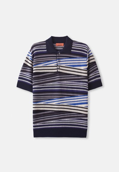 Polo majica s kratkimi rokavi s črtami, ki vključuje mornarsko modre, modre in kremne zigzag vzorce, gumbasto zapiranje ter rebrast ovratnik in rob.