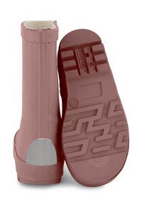 Bottes de pluie en caoutchouc roses avec une semelle texturée, un accent argenté au talon et un bord supérieur en forme de vagues. Matériau lisse et imperméable.
