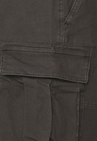 Donkergrauwe cargobroek van duurzaam materiaal, met een klepzak met knoopsluiting en zichtbare stikseldetails.