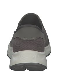 Zapatilla deportiva gris con parte superior de malla, collar acolchado y suela blanca. Presenta un diseño de perfil bajo y patrones de tela texturizados.