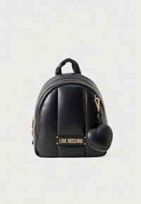 Melns ādas mugursoma ar šūtu dizainu, zelta aksesuāriem un zīmola plāksnīti. Aprīkota ar noņemamu sirds formas piekariņu.