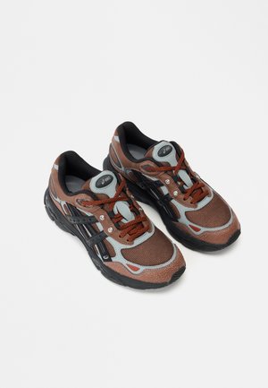 Braune und graue Sportschuhe mit Mesh-Obermaterial, schwarzer Gummisohle und reflektierenden Akzenten. Entworfen mit Schnürsenkeln und gepolsterten Kragen für Komfort.