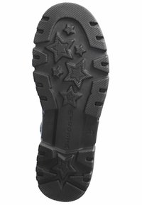 Suela de zapato de goma con un acabado negro texturizado. Presenta una superficie con tacos en forma de estrella y ranuras para mejorar la tracción, con la marca visible en el costado.