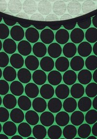 Fabric featuring a pattern of large black circles on a green background, with a solid black edge. Material appears smooth with a textured finish.