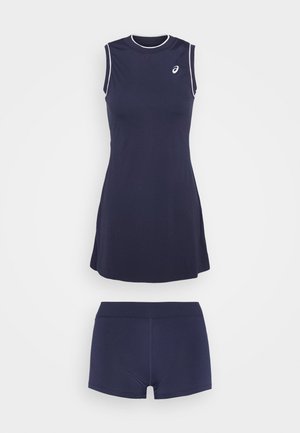Abito sportivo senza maniche di colore blu navy con inserti bianchi, dotato di scollatura rotonda e gonna svasata, abbinato a pantaloni corti blu navy coordinati sotto.