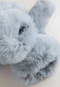 Soft, fluffy grey fur slippers with rounded edges. The texture is smooth and dense, featuring a plush appearance without visible seams.