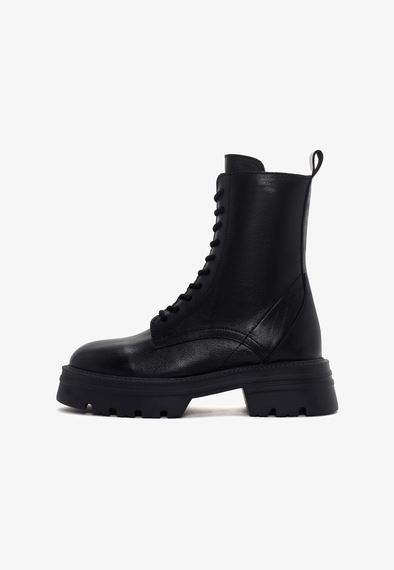 Botín negro de cuero hasta el tobillo con punta redonda, suela resistente y diseño con cordones. Cuenta con una lengüeta en el talón y un acabado texturizado.