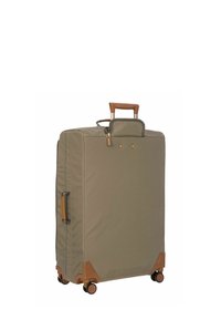 Valise en tissu vert avec une poignée supérieure, accents marron, quatre roues et une poche avant. Elle dispose de coins renforcés et de quincaillerie dorée.