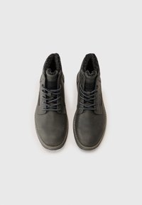 Botine negre din piele întunecată, cu un interior pufoș de culoare neagră, detalii cusute și șireturi gri. Design cu vârf rotund și talpă din cauciuc.