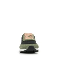 Zapatilla negra y verde con una puntera de ante, cordones beige, suela blanca y detalles texturizados en la parte superior. La vista frontal resalta la forma y el diseño.