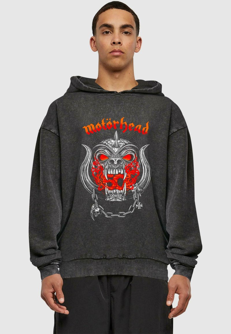 Čierna mikina s kapucňou featuring veľký grafický dizajn lebky s červenými akcentmi a kovovými detailmi, logo znie "motörhead."