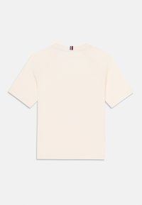 Ljusbeige kortärmad T-shirt med rundad halsringning har en randig detalj på baksidan. Enfärgad, enkel design.