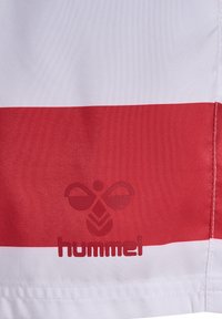 Hummel Sportstoff mit horizontalen roten und weißen Streifen. Ein strukturiertes Logo in der Mitte, mit glattem Material.