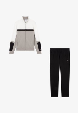 Completo sportivo composto da una giacca con zip grigia e bianca con dettagli neri e pantaloni neri abbinati. Tessuto in misto cotone.
