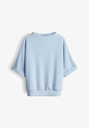 Lichtblauw sweatshirt met korte mouwen, opgerolde manchetten, ronde hals en elastische zoom, weergegeven op een witte achtergrond.