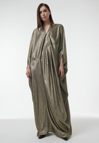 Kaftan en métal doré avec un design ample et drapé, caractérisé par un col en V, des épaules tombantes et un détail de poche minimaliste. Texture lisse et réfléchissante.