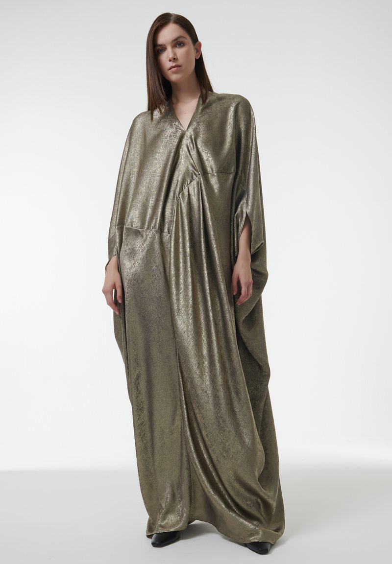Kaftan en métal doré avec un design ample et drapé, caractérisé par un col en V, des épaules tombantes et un détail de poche minimaliste. Texture lisse et réfléchissante.
