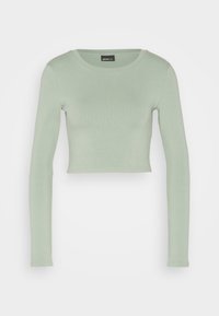 Lys grøn cropped langærmet ribbet top med rund halsudskæring, tætsiddende pasform og Gina Tricot mærke indeni kraven.
