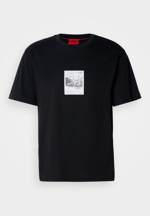 T-shirt de algodão preto com mangas curtas, apresentando uma impressão gráfica dentro de uma moldura retangular branca. Acento do logótipo em vermelho no canto inferior direito.