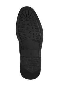 Semelle de chaussure en caoutchouc noir avec un motif de grip texturé, arborant le nom de la marque "Tamaris" et la taille "42". Design à talon plat pour plus de stabilité.