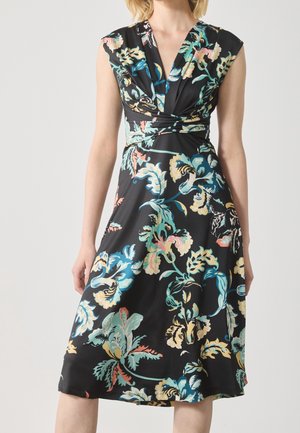 Czarna sukienka bez rękawów z głębokim dekoltem w kształcie litery V i wielokolorowym dużym kwiatowym wzorem na zwiewnej spódnicy o długości do połowy łydki.