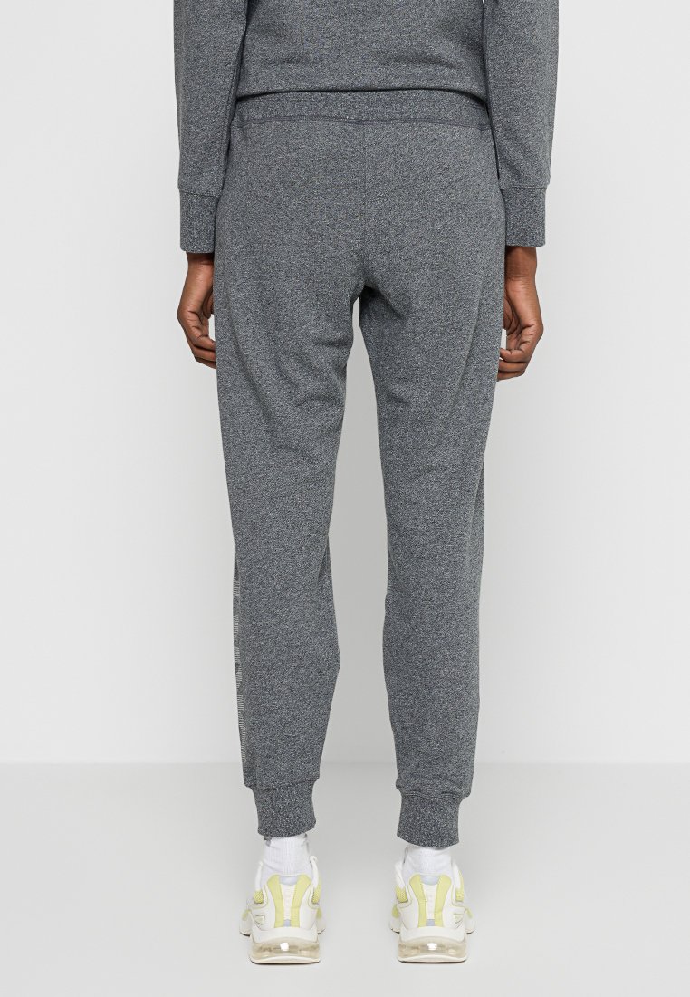 Szare, taperowane joggery wykonane z miękkiej tkaniny, z elastycznym pasem i mankietami. Subtelna tekstura, z bocznymi paskami i swobodnym stylem.