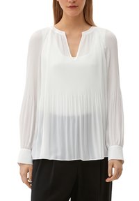 Blouse blanche à manches longues avec un design pliss&eacute;, décolleté en V et manches à poignet. Fabriquée en tissu léger et transparent. Texture lisse.