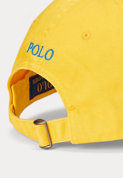 Κίτρινο καπέλο μπέιζμπολ με μπλε κέντημα "POLO", ρυθμιζόμενο λουράκι με μεταλλικό κουμπωτό και ορατή εσωτερική ετικέτα.