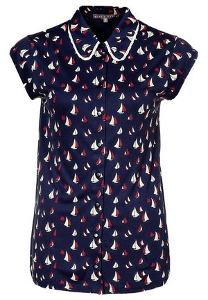 Blouse bleu marine à manches courtes avec motifs de voiliers blancs et rouges, boutonnée sur le devant, et col arrondi avec bordure blanche.