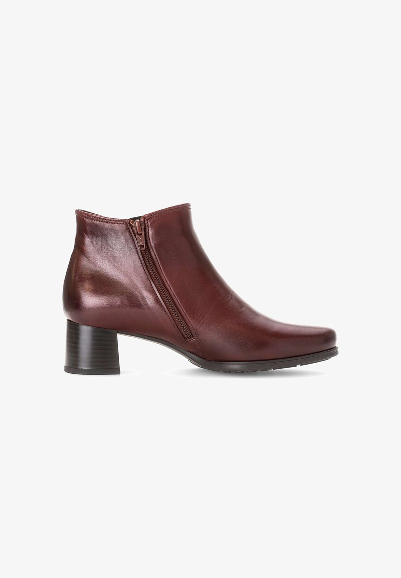 Bottines en cuir bordeaux avec un bout rond, une fermeture éclair latérale et un talon noir empilé. Texture lisse et design épuré.