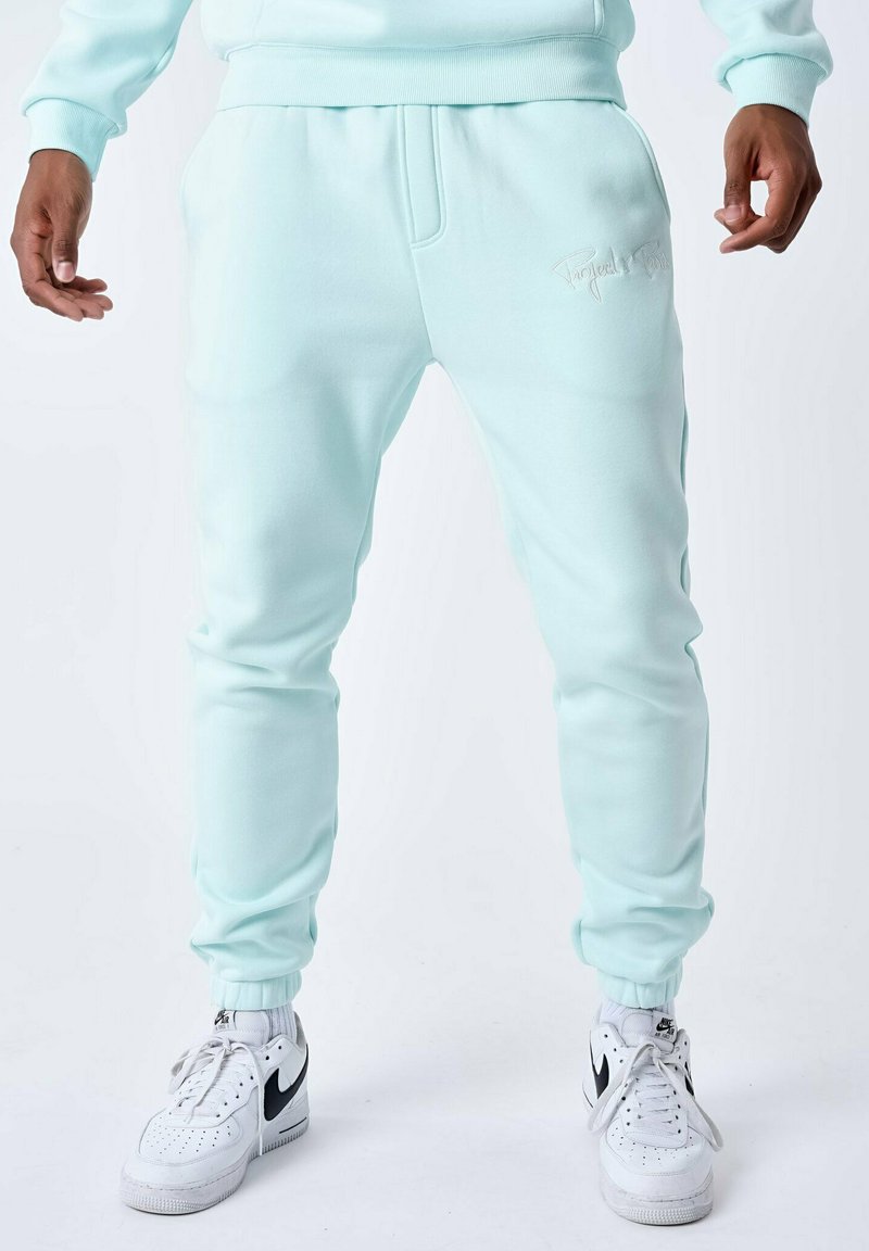 Pantalones de chándal en verde menta claro, hechos de un tejido suave, conuna cinturilla elástica, puños acanalados y un sutil logotipo bordado en el lateral.